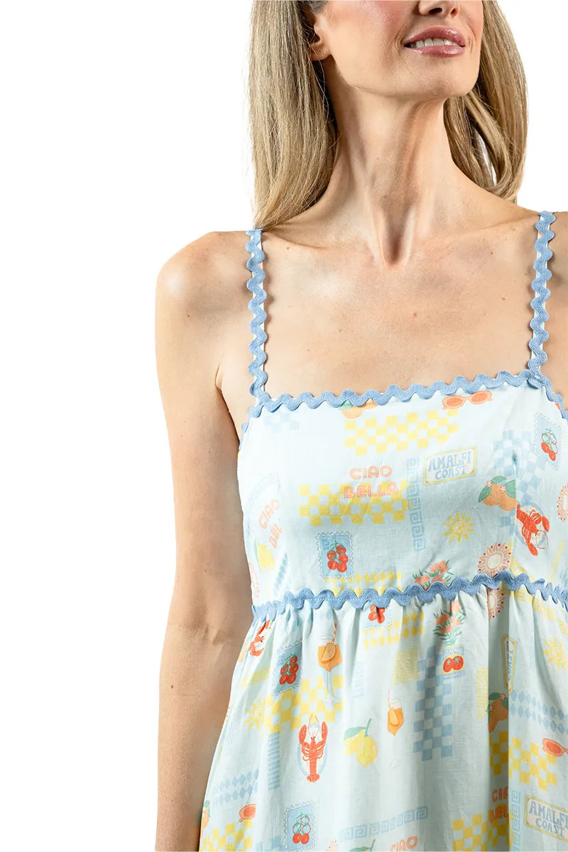 Woman wearing a light blue dress with floral pattern and lace trim on a white background