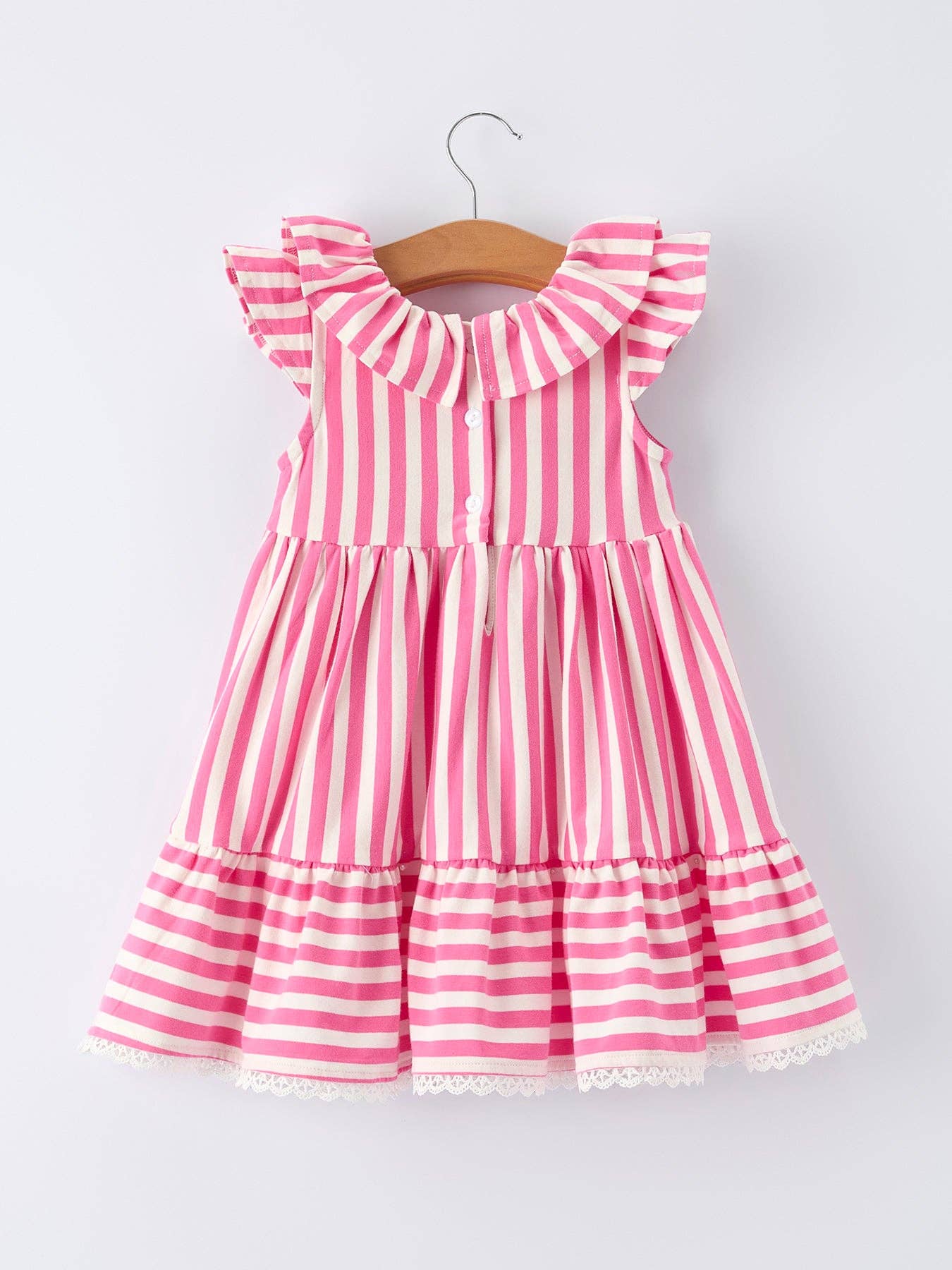 Pink and white striped dress on a hanger against a light gray background