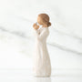 Ceramic figurine of a woman holding a heart-shaped object on a white background