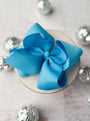 Blue bow on a white surface with silver decorative elements
