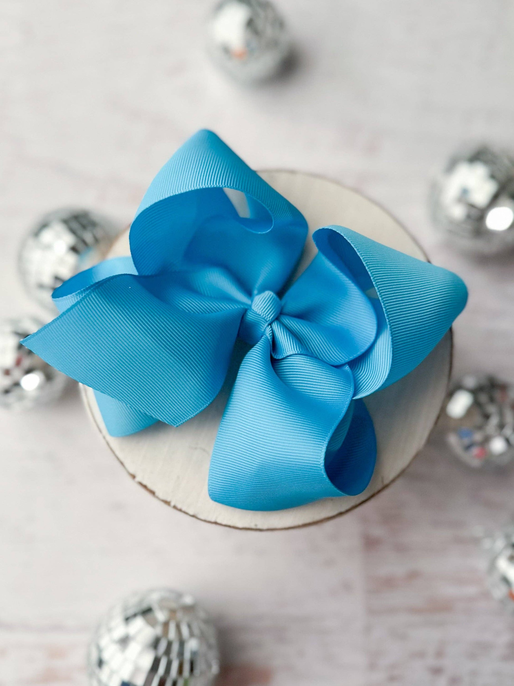 Blue bow on a white surface with silver decorative elements
