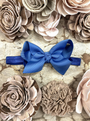 Blue hair bow on a textured surface with floral decorations