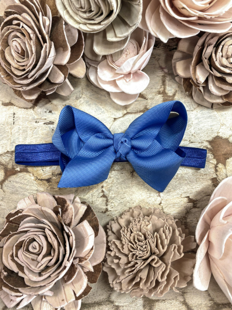 Blue hair bow on a textured surface with floral decorations