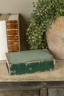 Vintage books and a vase with greenery on a wooden surface