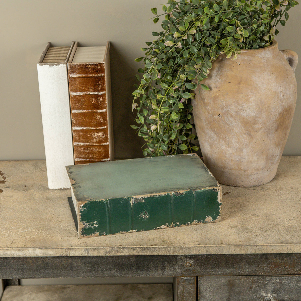 Vintage books and a vase with greenery on a wooden surface