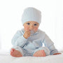 Baby in light blue outfit with matching hat on a white background