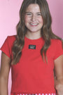 Two girls wearing red and pink shirts with a visible brand logo on a pink background