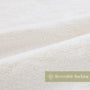 Close-up of white fabric with 'Reversible Backing' label