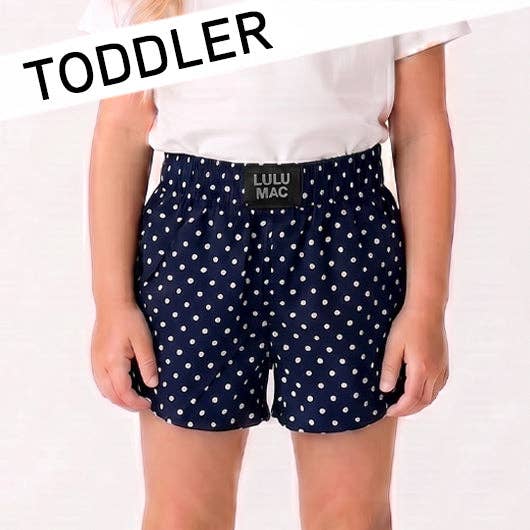 Navy blue polka dot shorts with a visible brand label on a white background, labeled 'TODDLER'.