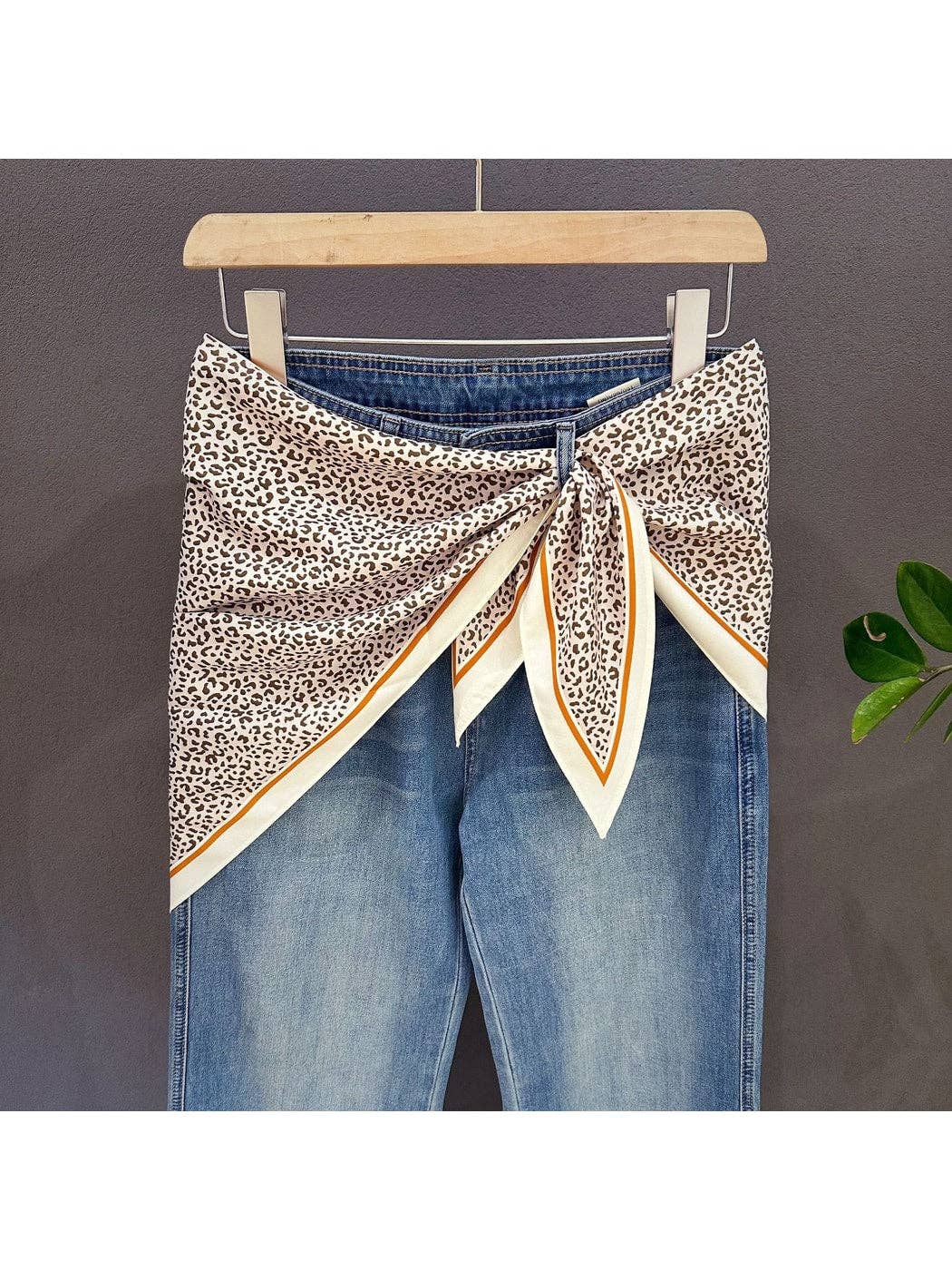 Leopard print triangle bandana with cream and green contrast border, tied at center