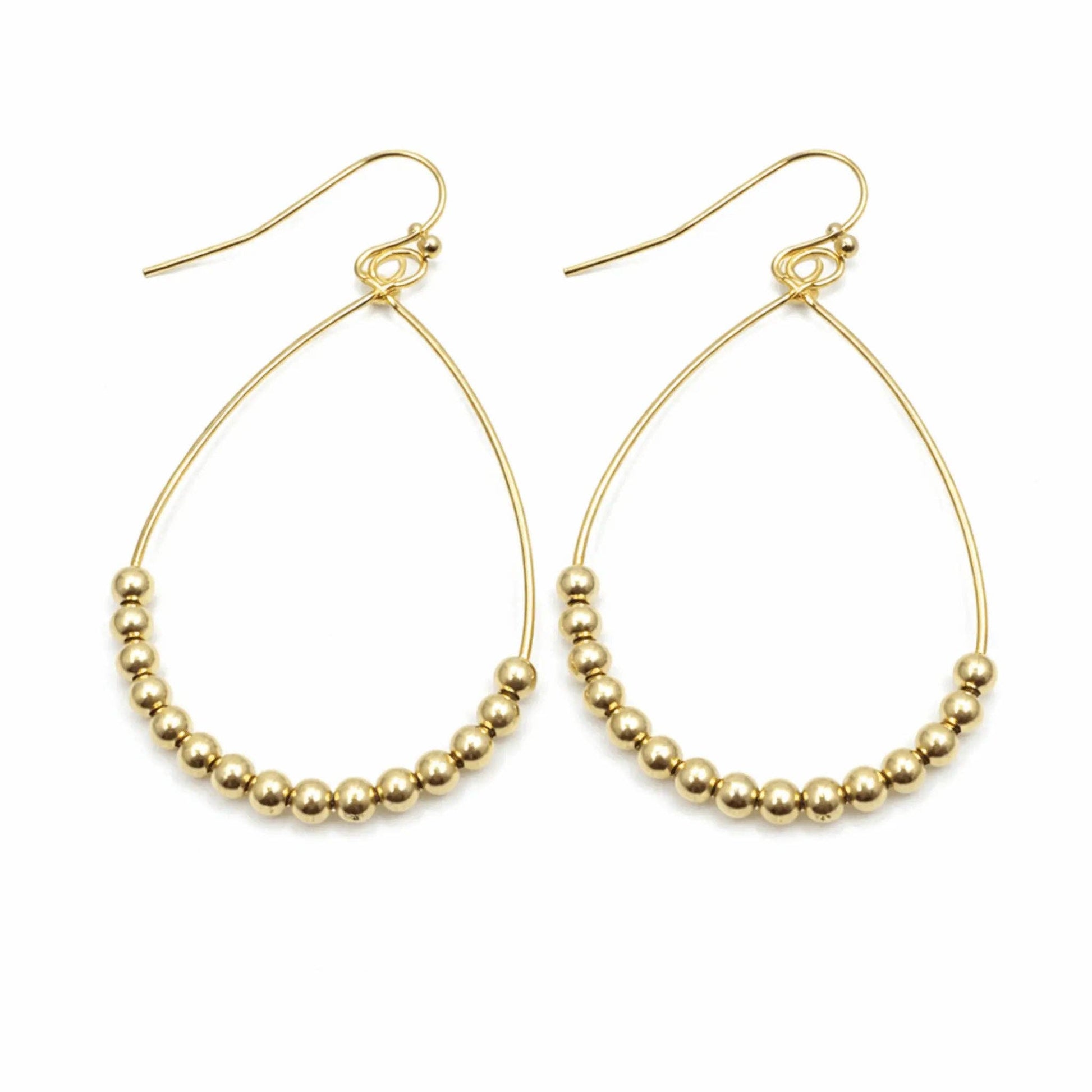 Gold hoop earrings with bead detailing on a white background