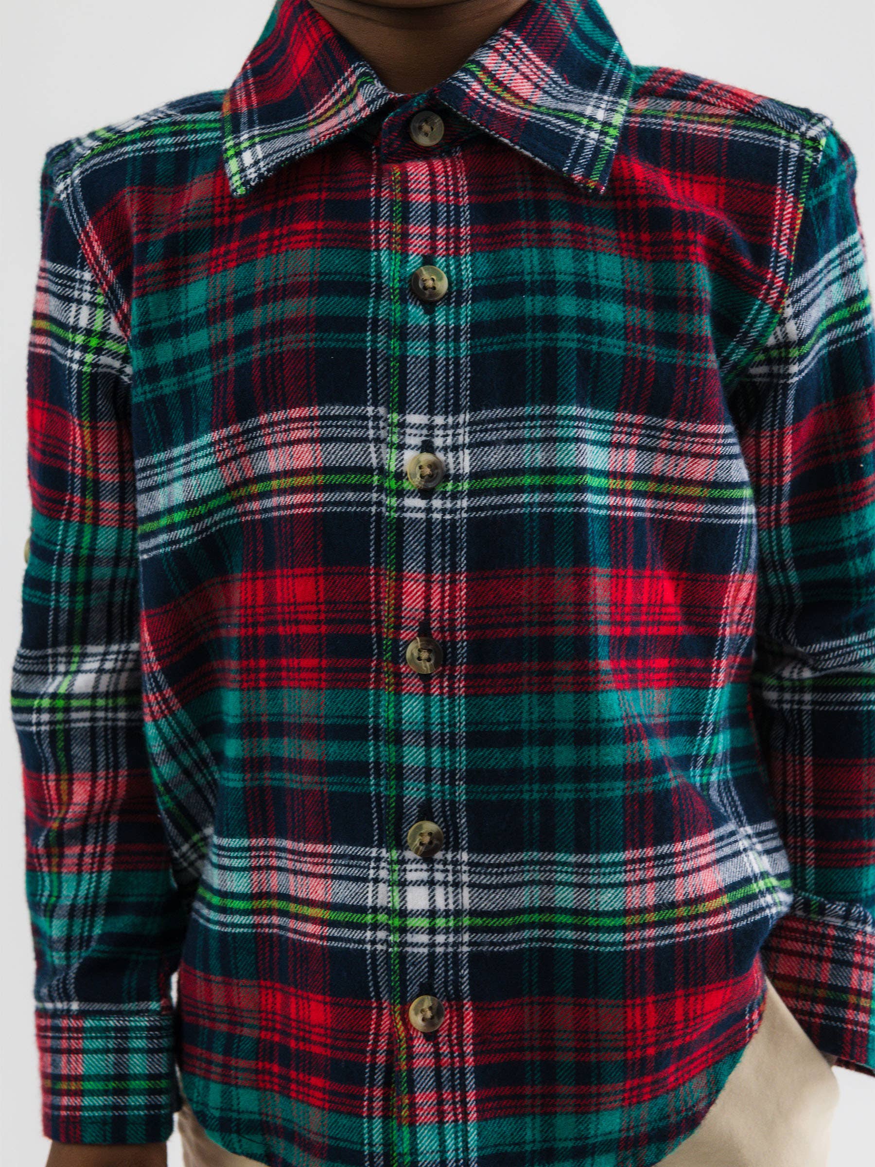 Plaid shirt with red, green, and white pattern on a plain background