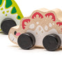 Wooden toy car with a dino design on a white background
