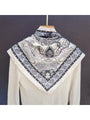 Muted grey triangle bandana scarf with vintage paisley pattern, folded near collar