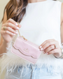 Person holding a pink handbag with a gold chain
