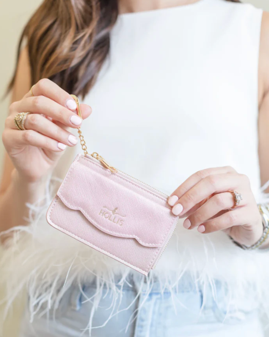 Person holding a pink handbag with a gold chain