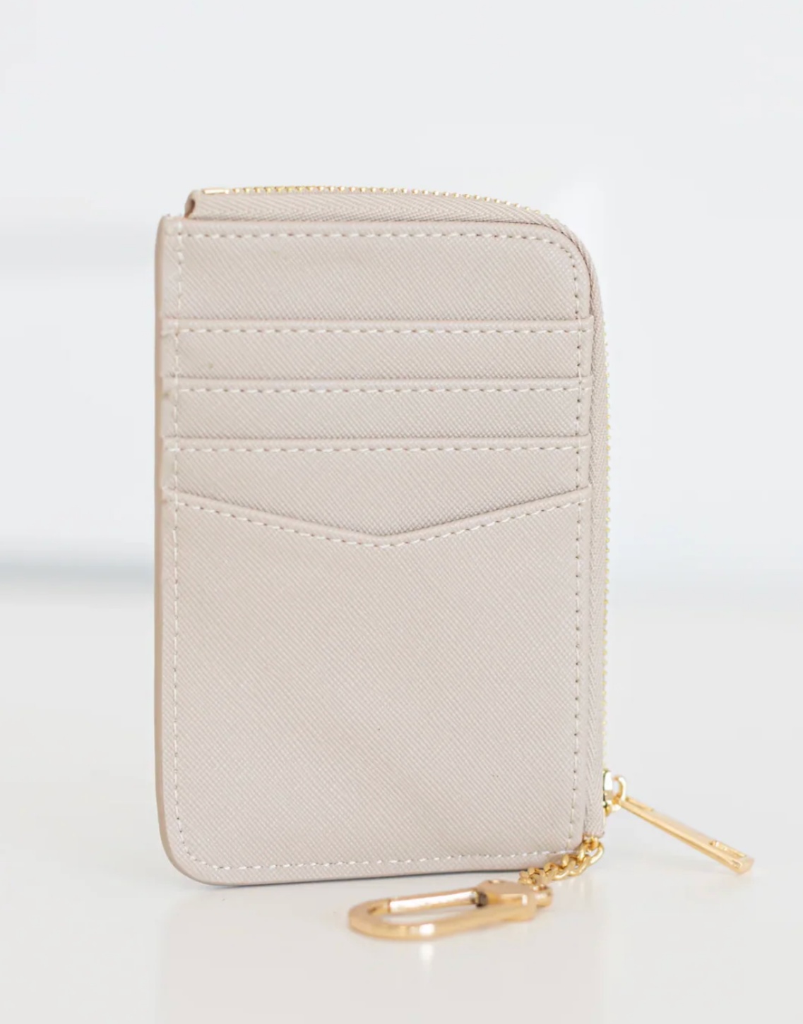 Light gray wallet with gold zipper on a white background