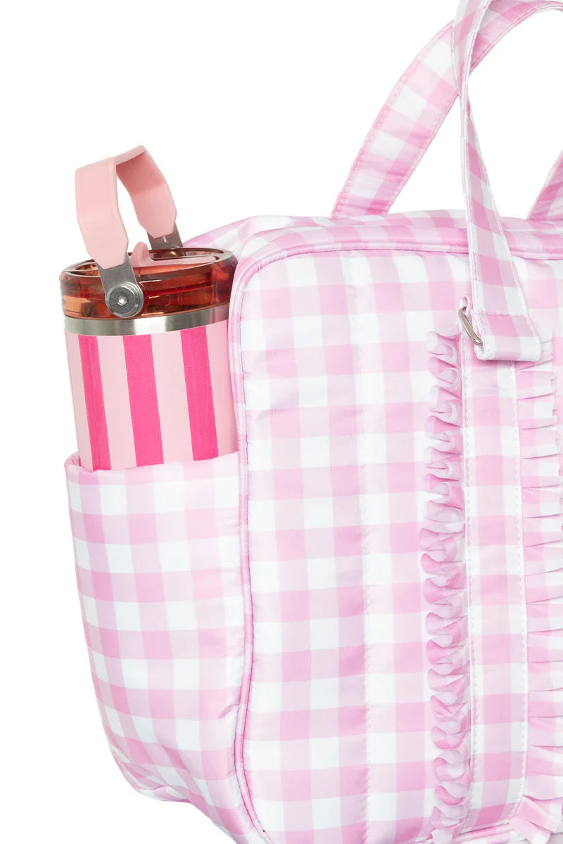 Pink gingham patterned bag with a water bottle in a pocket on a white background