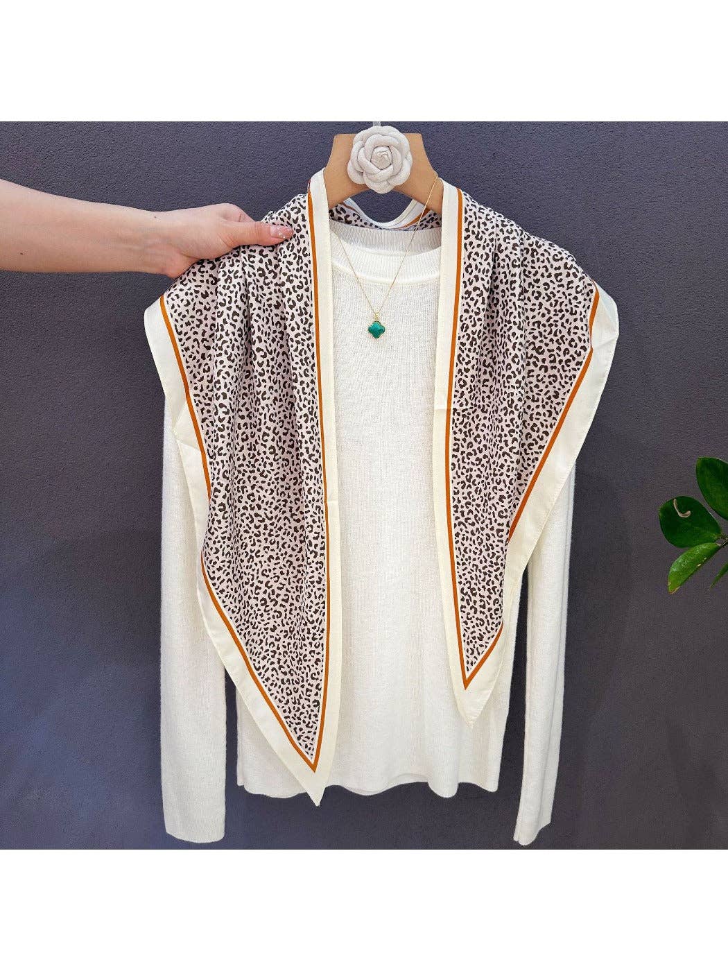 Leopard print scarf bandana with cream base, green and peach contrast borders on hanger