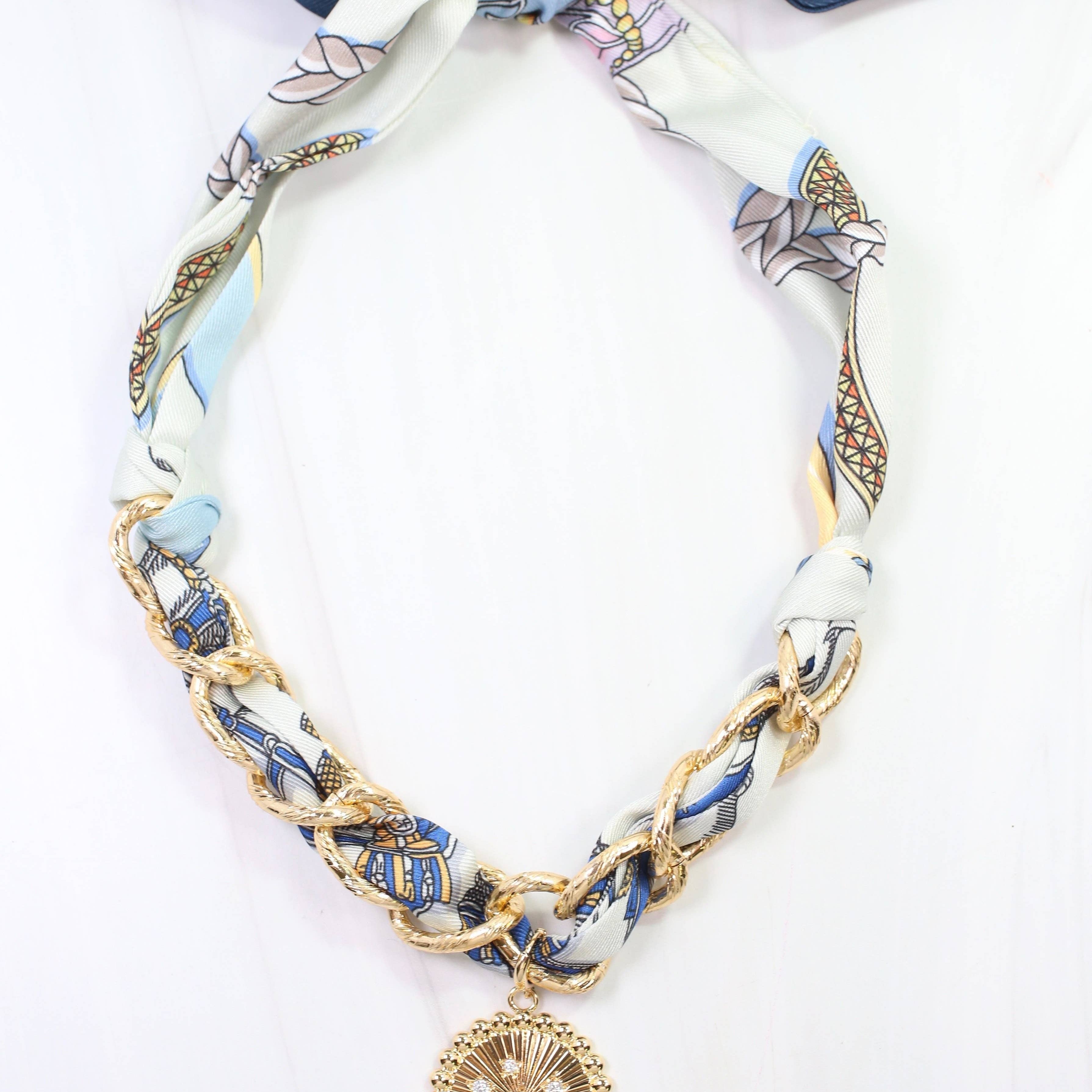 Necklace with a decorative pendant on a patterned ribbon against a white background