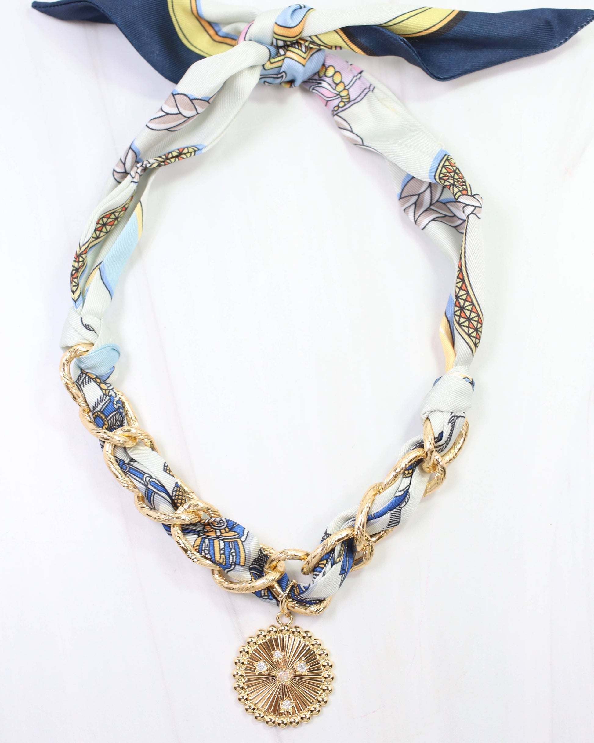 Necklace with a decorative pendant on a patterned ribbon against a white background