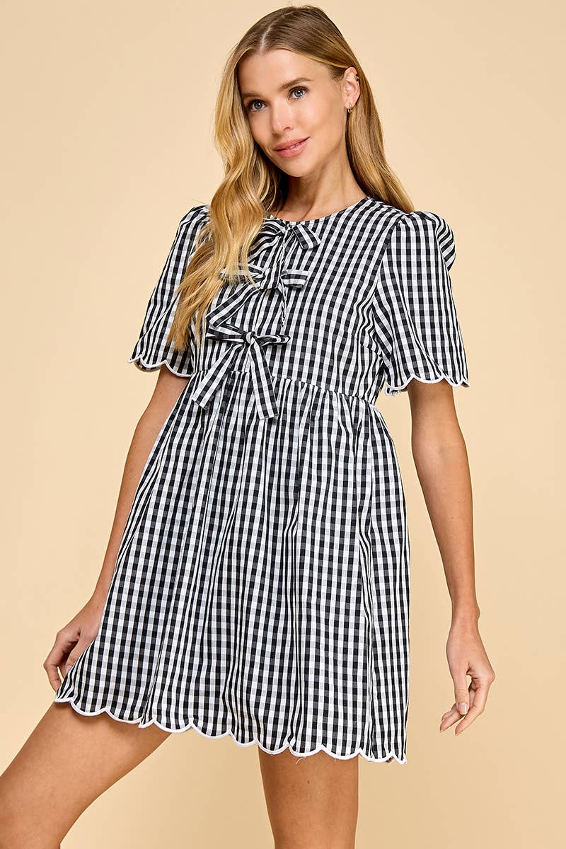 Woman wearing a black and white checkered dress on a beige background