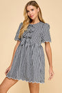 Woman wearing a black and white checkered dress on a beige background