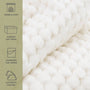 Close-up of a white fur throw with text describing its features on the left.