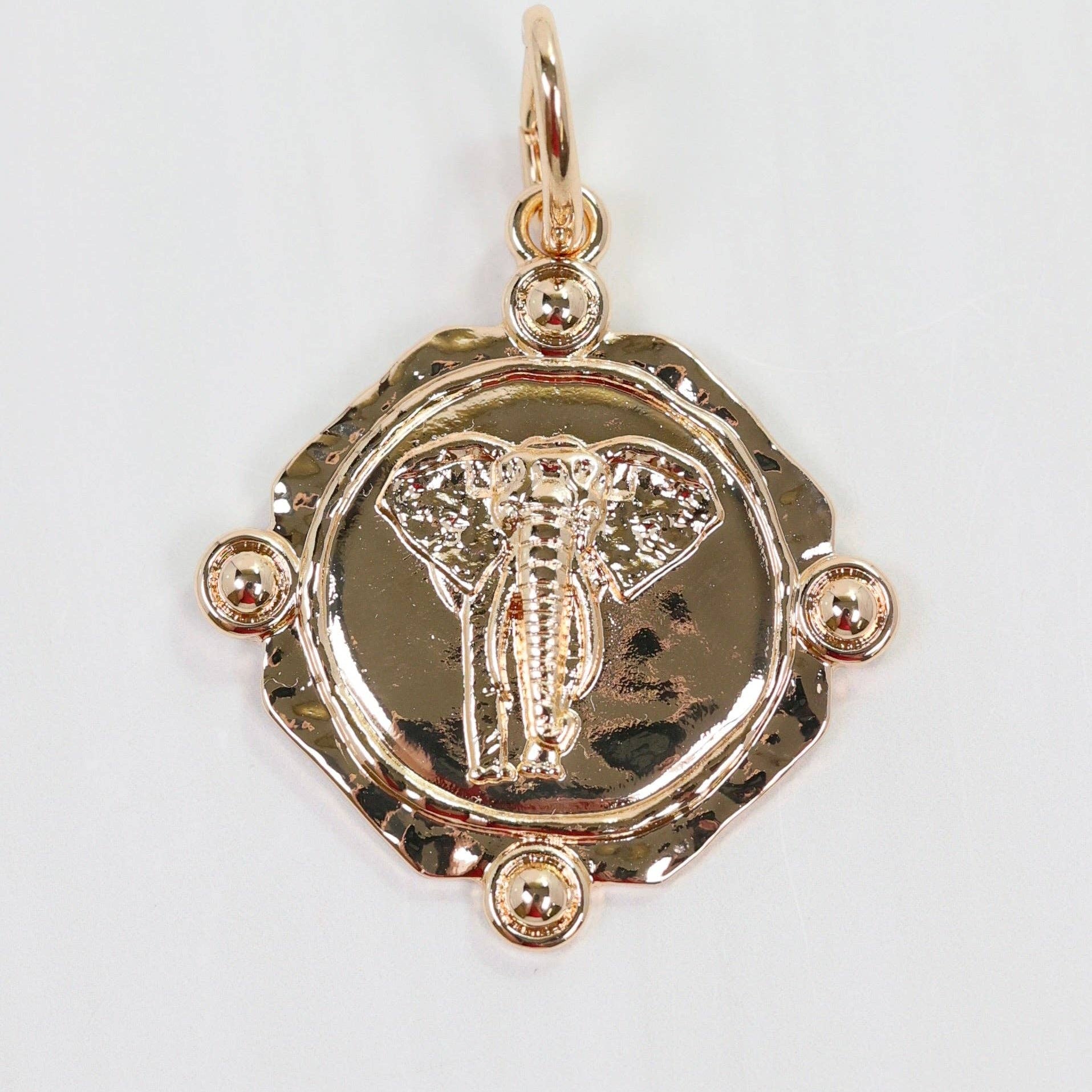 Gold pendant with intricate design on a white background