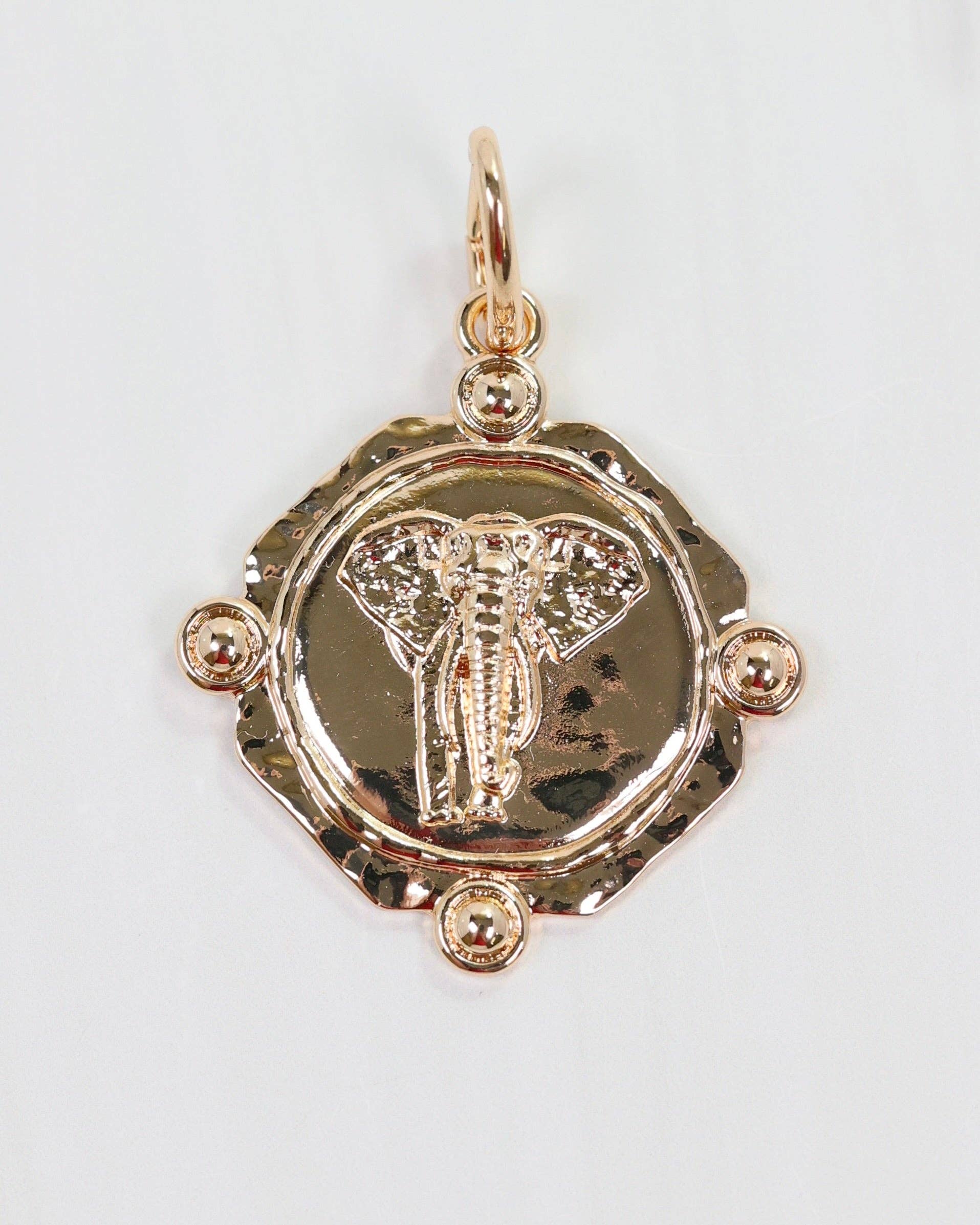 Gold pendant with intricate design on a white background