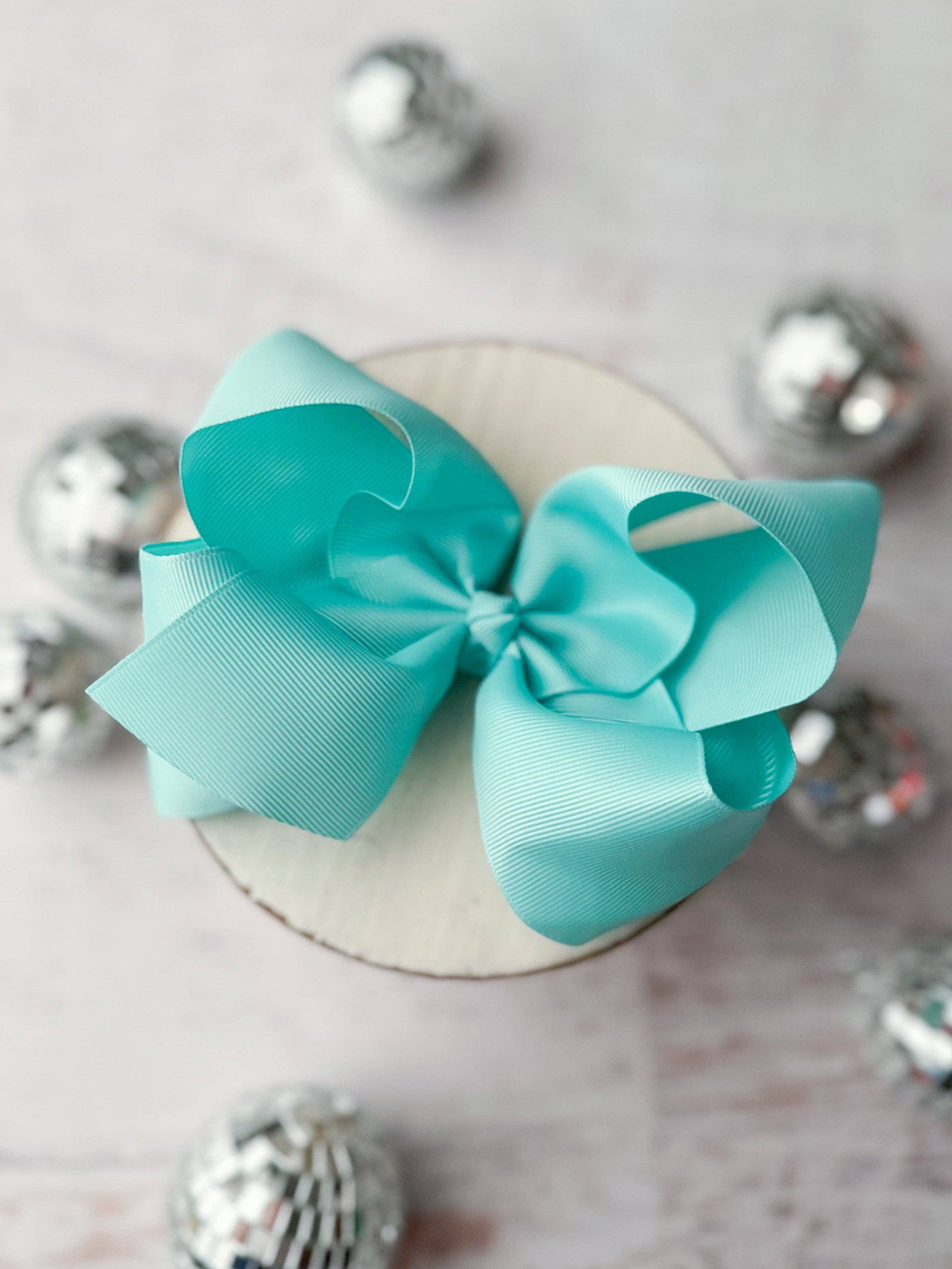 Turquoise bow on a white plate with silver decorative elements