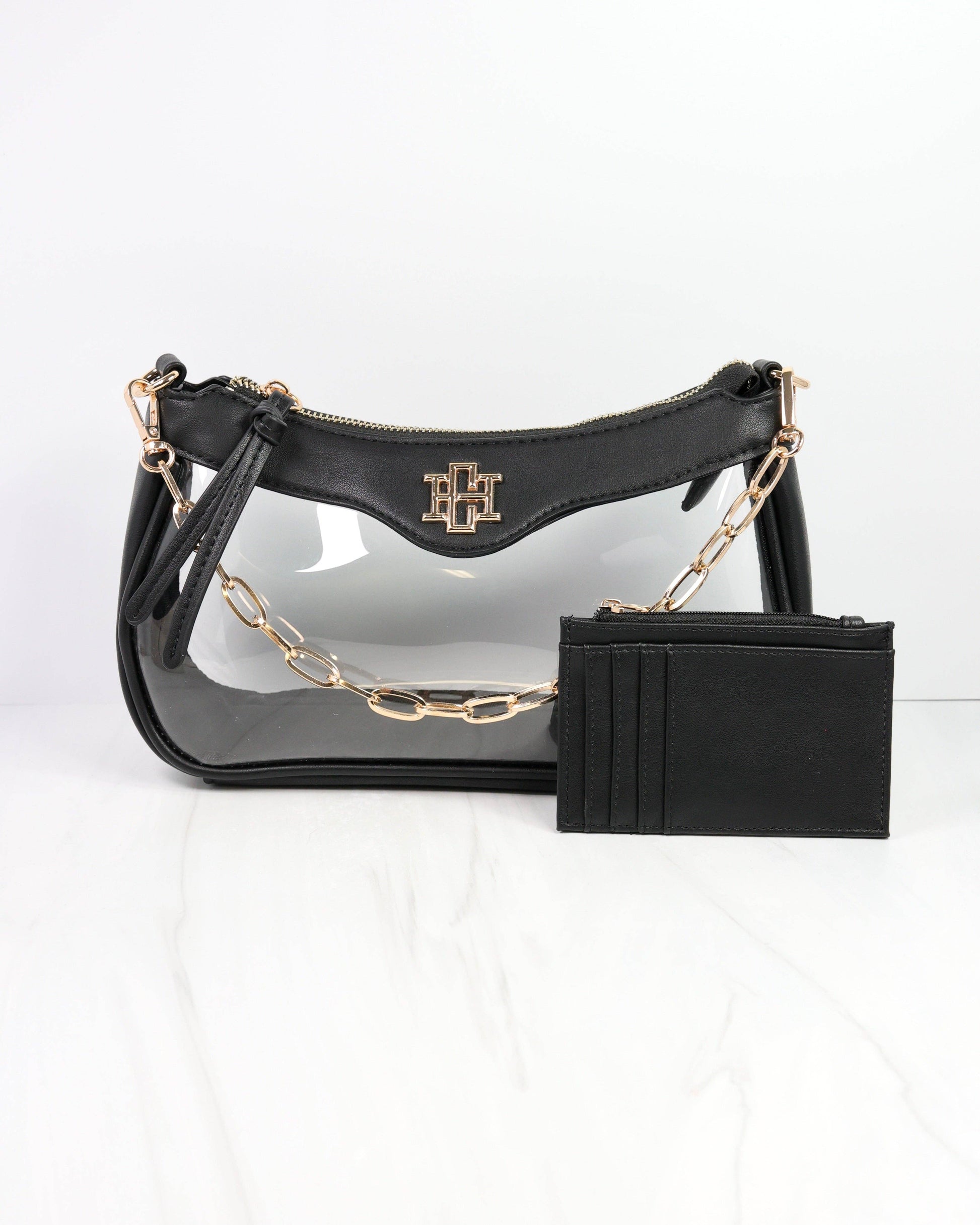 Black handbag with gold chain and matching black wallet on a white background