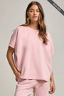 Woman wearing a pink outfit on a gray background