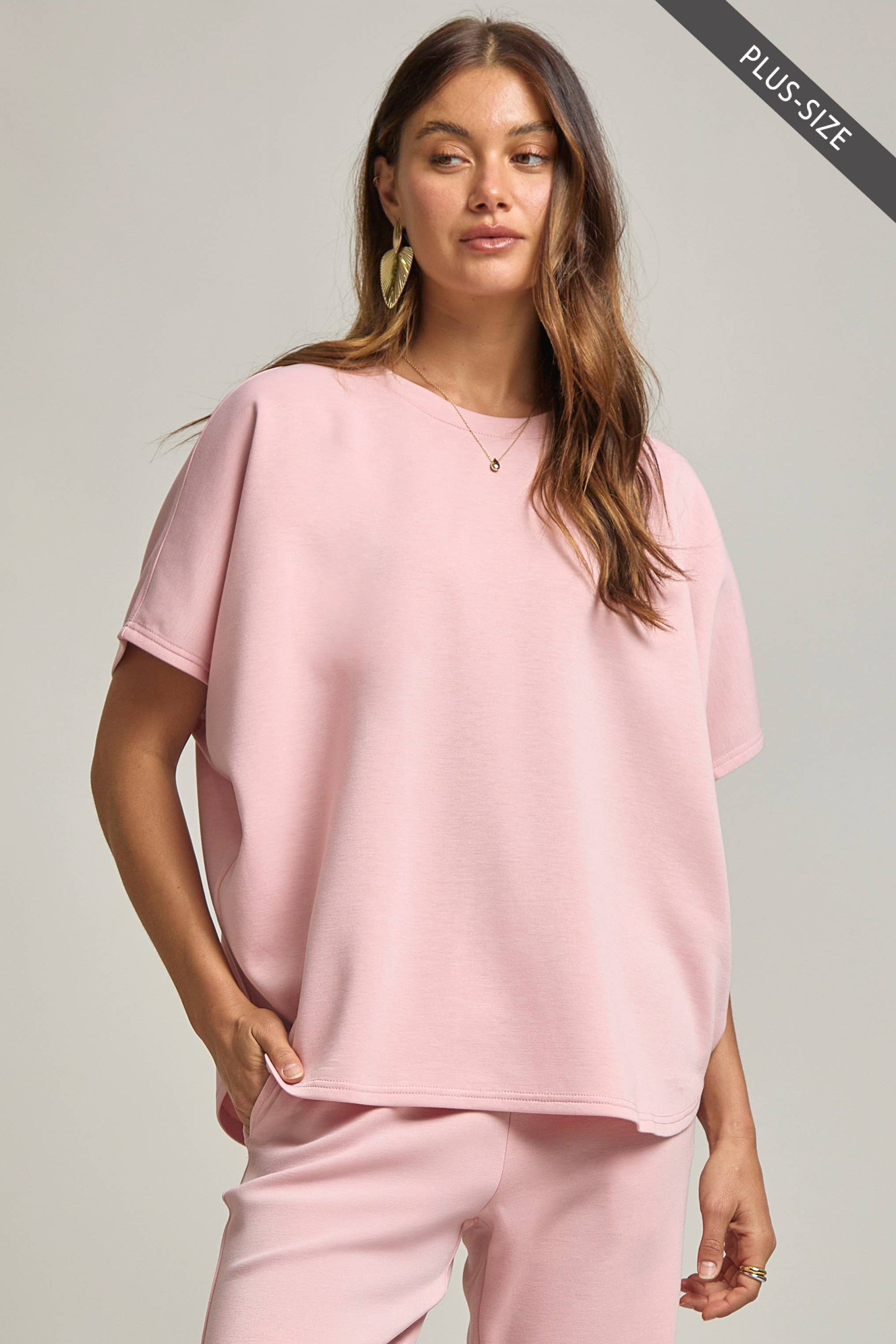 Woman wearing a pink outfit on a gray background