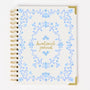 Devotional journal with blue floral design and gold text on a white background
