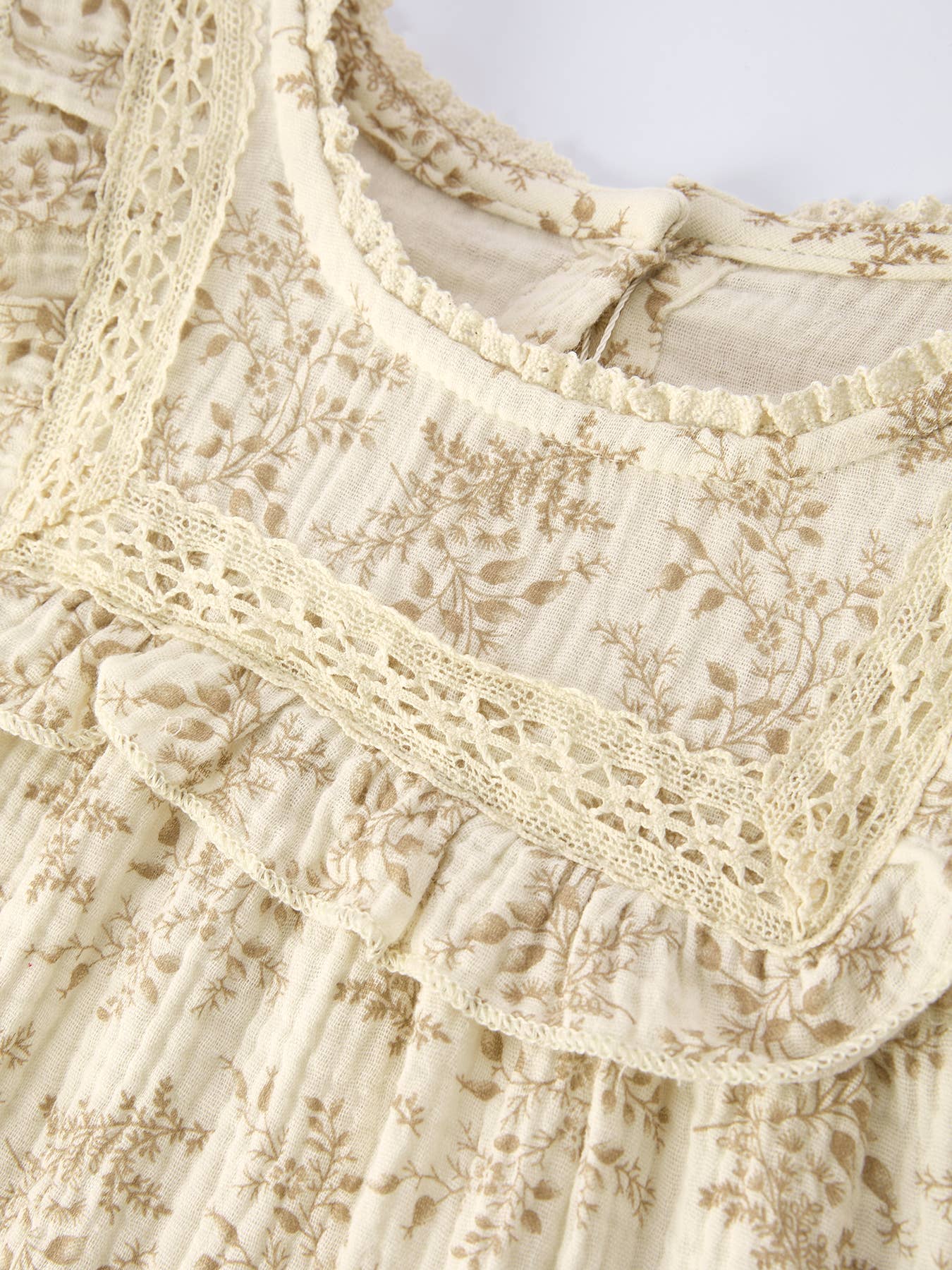 Close-up of a cream-colored lace garment with intricate patterns.
