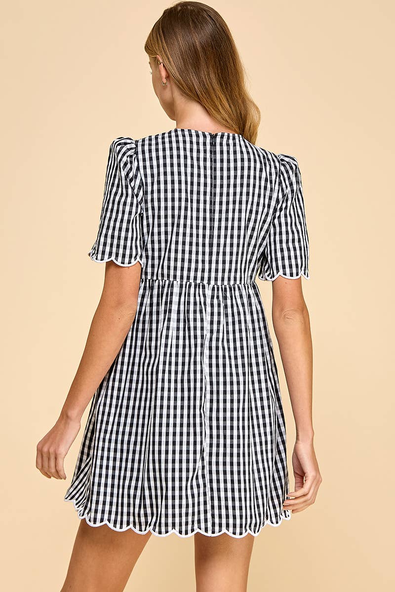 Woman wearing a black and white checkered dress on a beige background