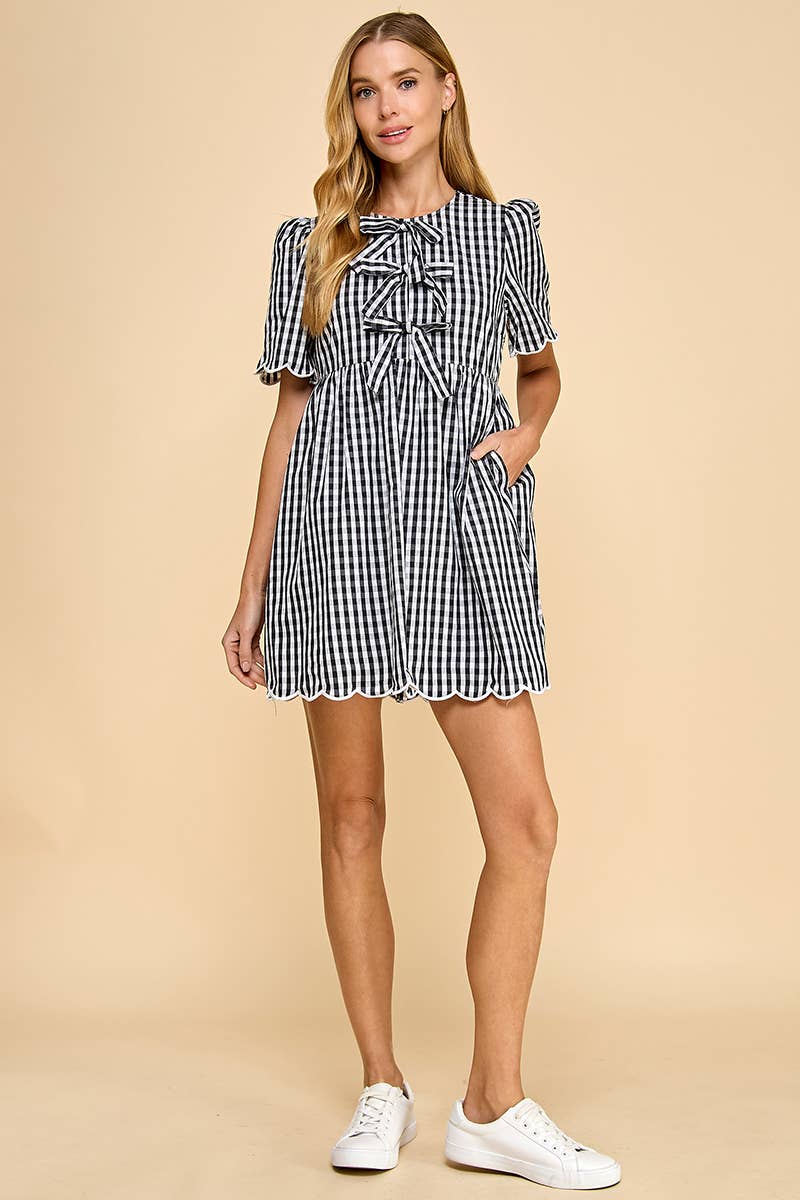 Woman wearing a black and white checkered dress on a beige background