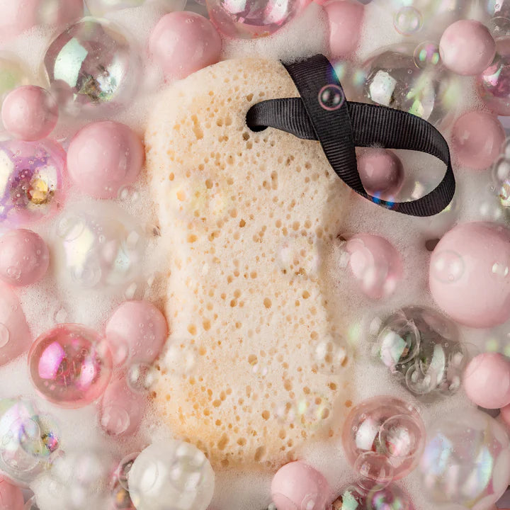 Sponge with a black hair tie surrounded by pink and clear bubbles