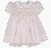 Pink baby dress with lace details on a white background