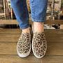 Pair of leopard print slippers on a neutral background