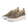 Animal print slip-on sneakers with a white sole on a neutral background