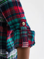 Close-up of a plaid shirt with a button on a white background