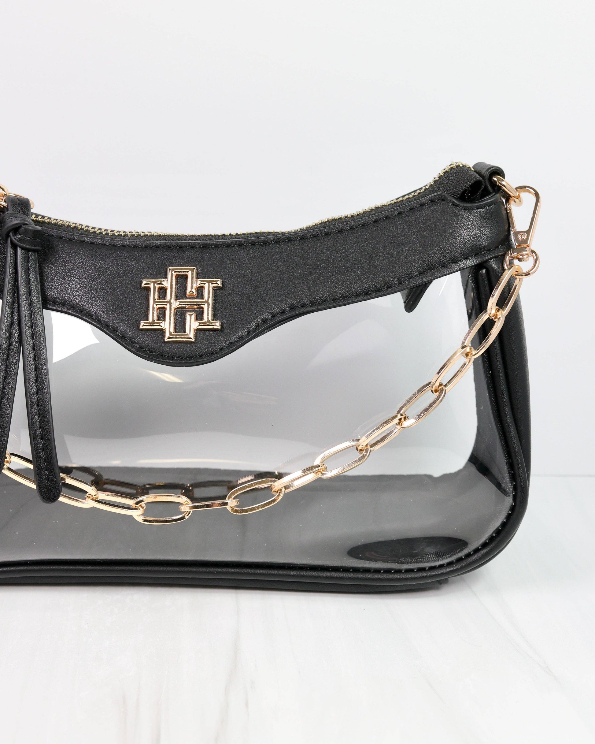 Black handbag with gold chain strap on a white background