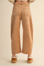 Tan corduroy pants worn by a person on a beige background