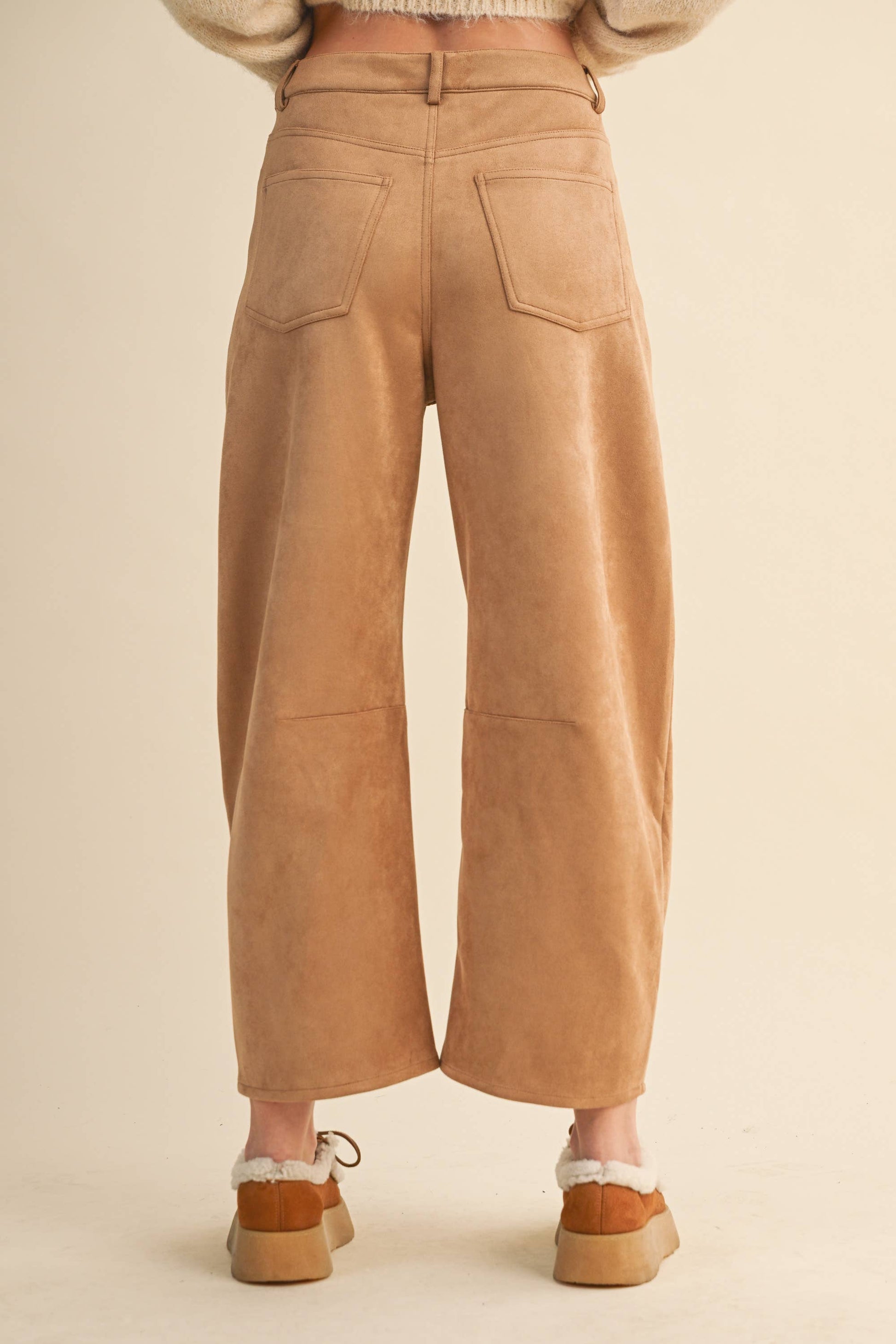 Tan corduroy pants worn by a person on a beige background
