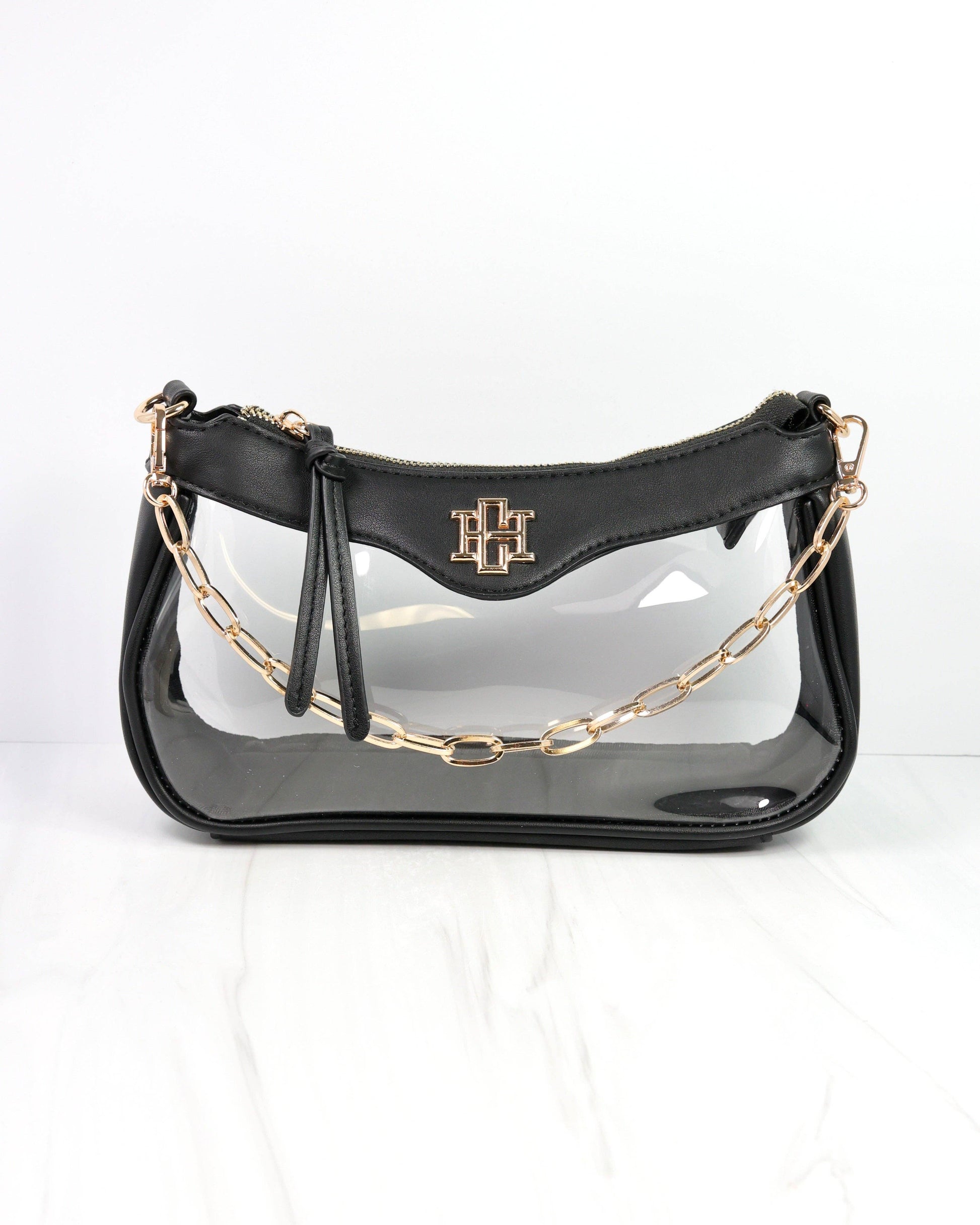Black handbag with gold chain strap on a white background