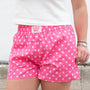 Pink polka dot shorts with 'Lulu Mac' branding worn by a person.
