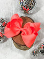 Red bow on a wooden block with disco balls in the background