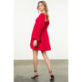 Woman wearing a red dress with long sleeves on a white background